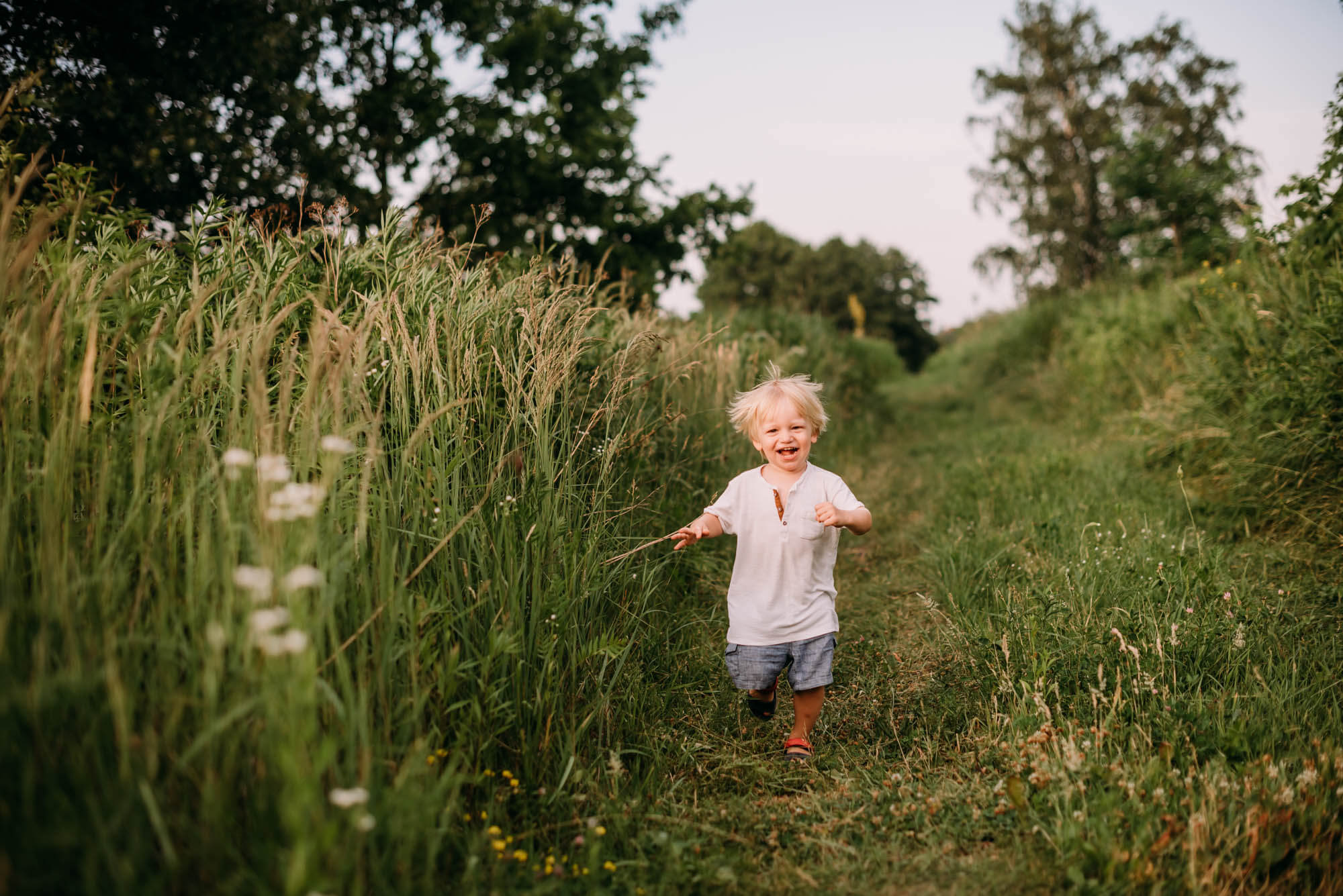 mały chłopiec biegnie po trawie