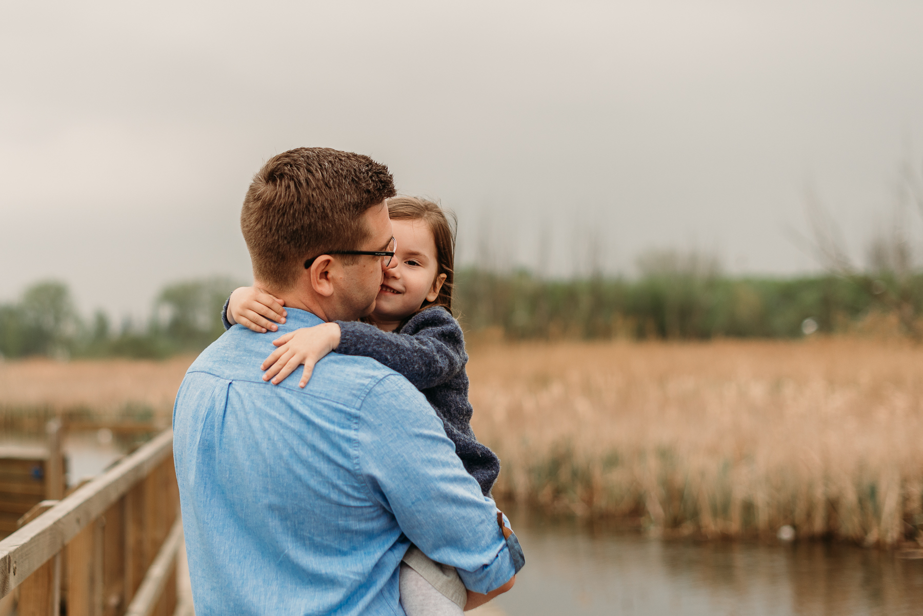 Sesja rodzinna w plenerze Warszawa - tata trzyma dziecko na rękach podczas sesji na której warto uniknąć tych 5 błędów