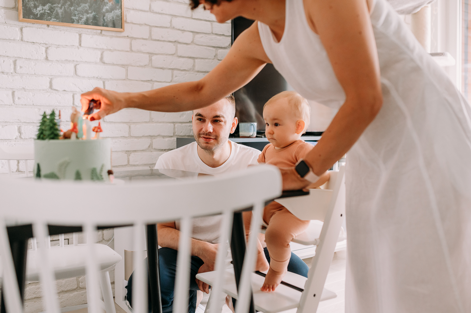 mama zapala świeczkę na pierwsze urodziny