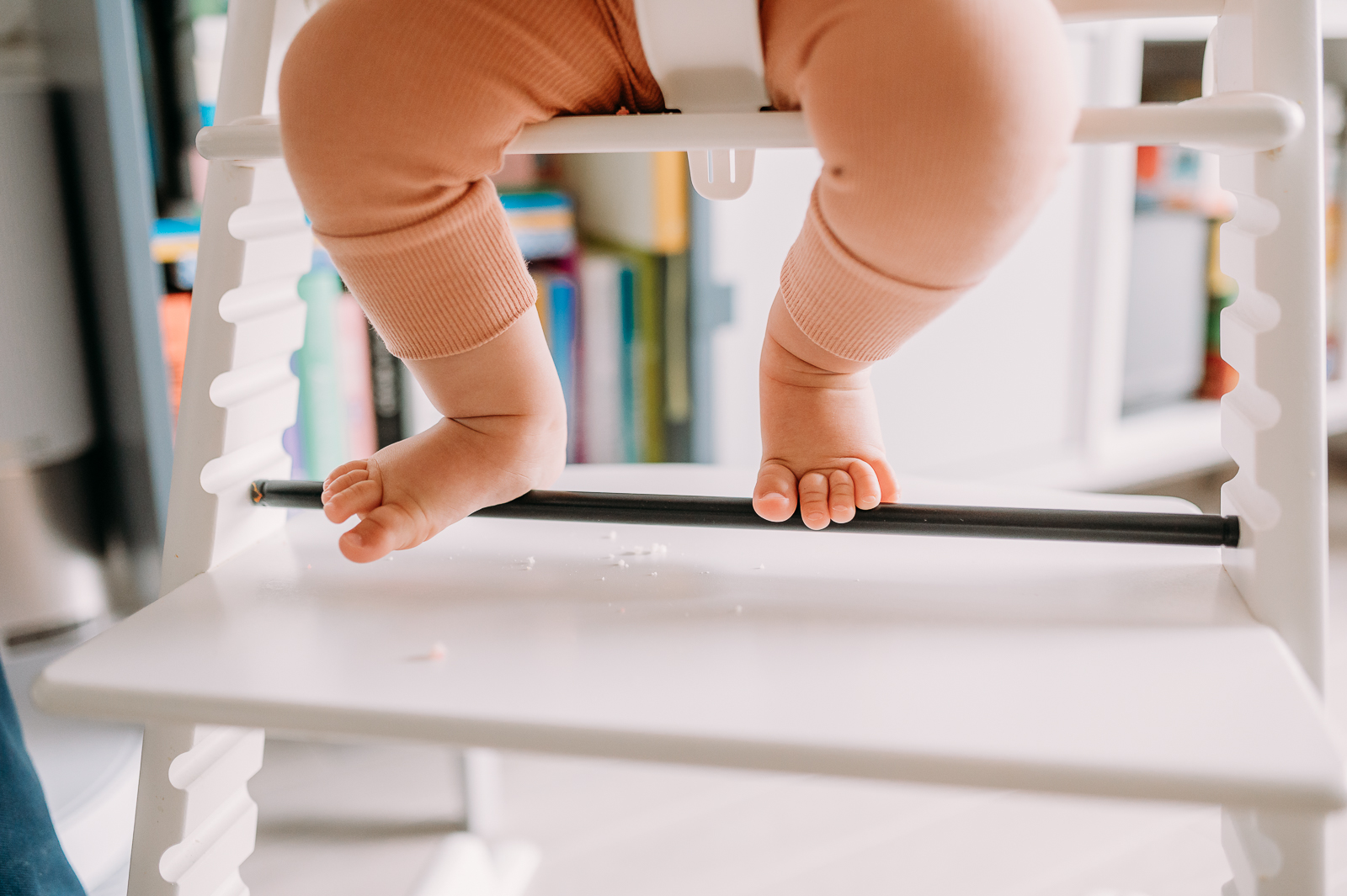 stopy rocznego dziecka siedzącego w krzesełku