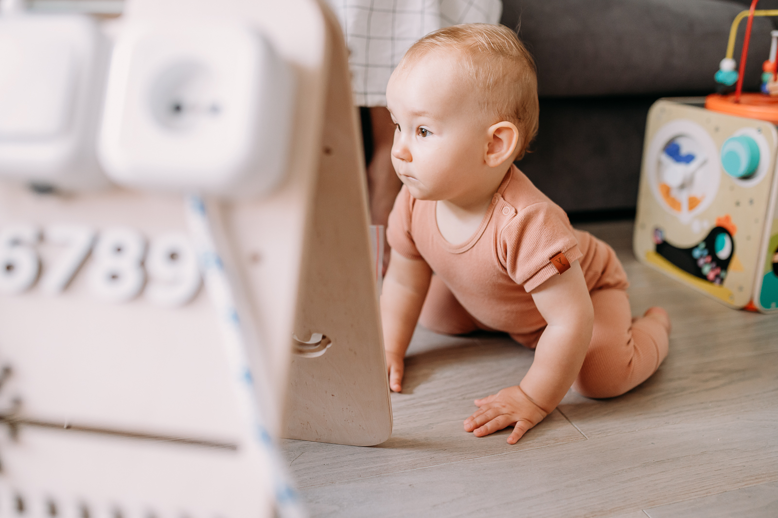 dziecko bawi się przy tablicy manipulacyjnej