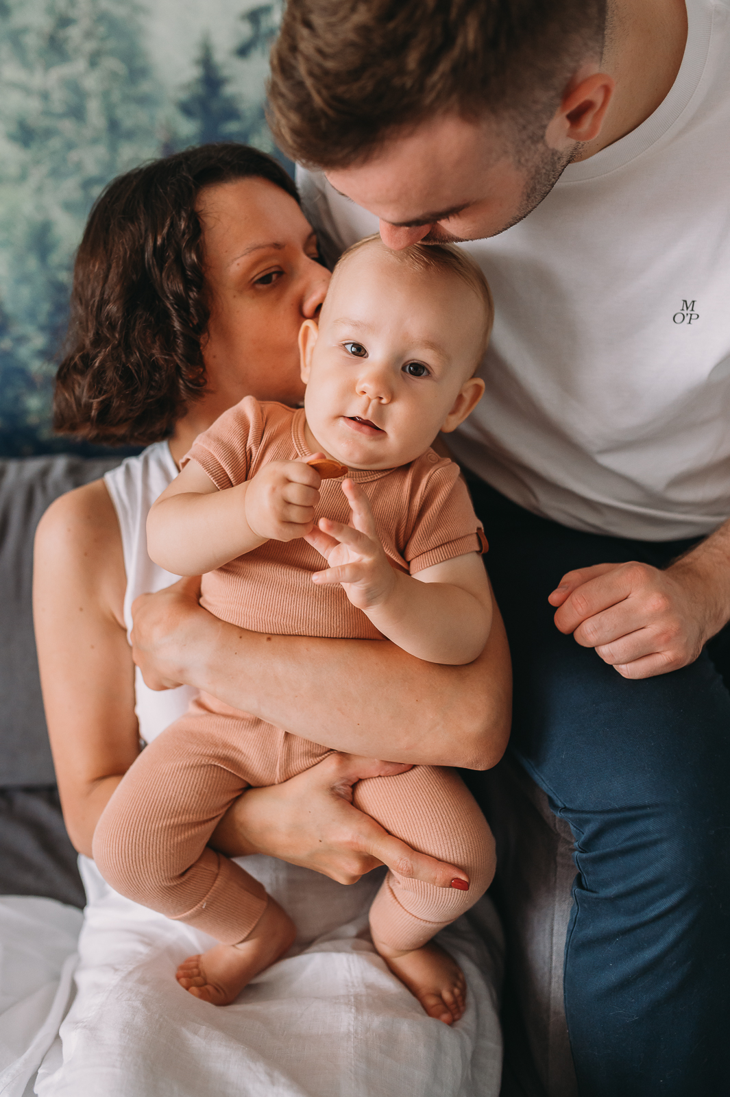 mama z tatą całują roczne dziecko