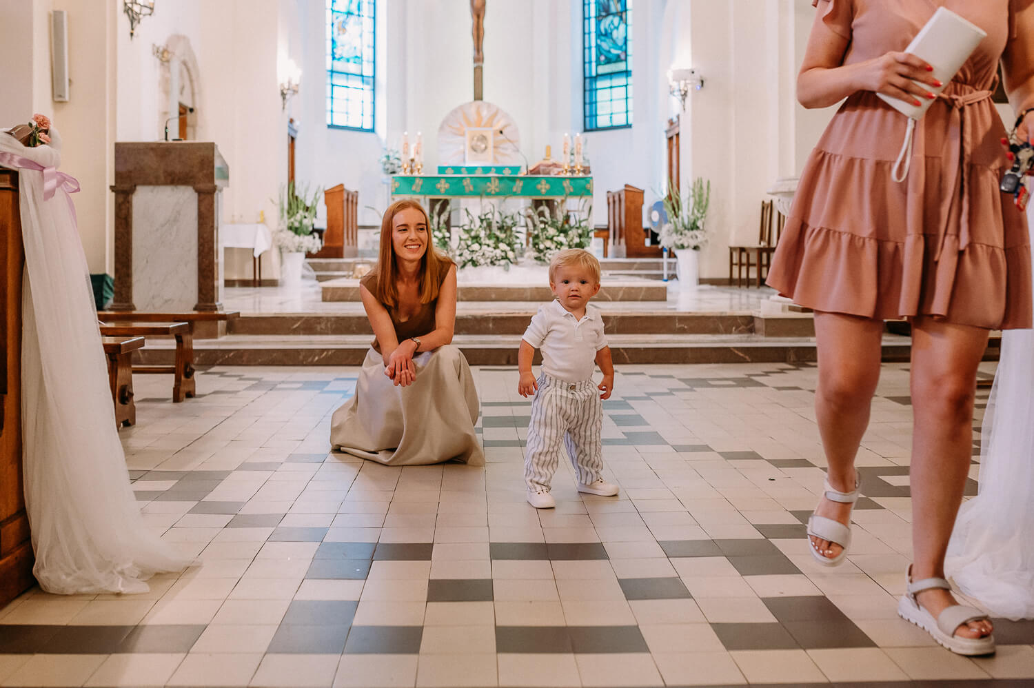 mama stoi z dzieckiem na tle ołtarza