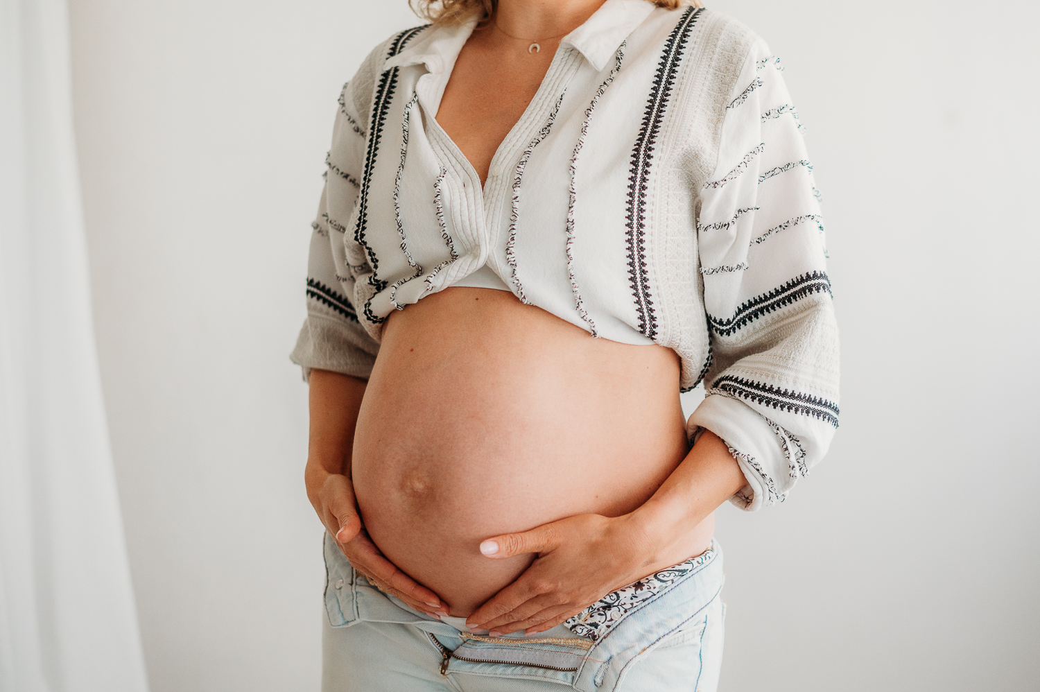 Najczęstsze pytania przyszłych mam - zbliżenie na brzuszek ciążowy podczas sesji ciążowej<br />

