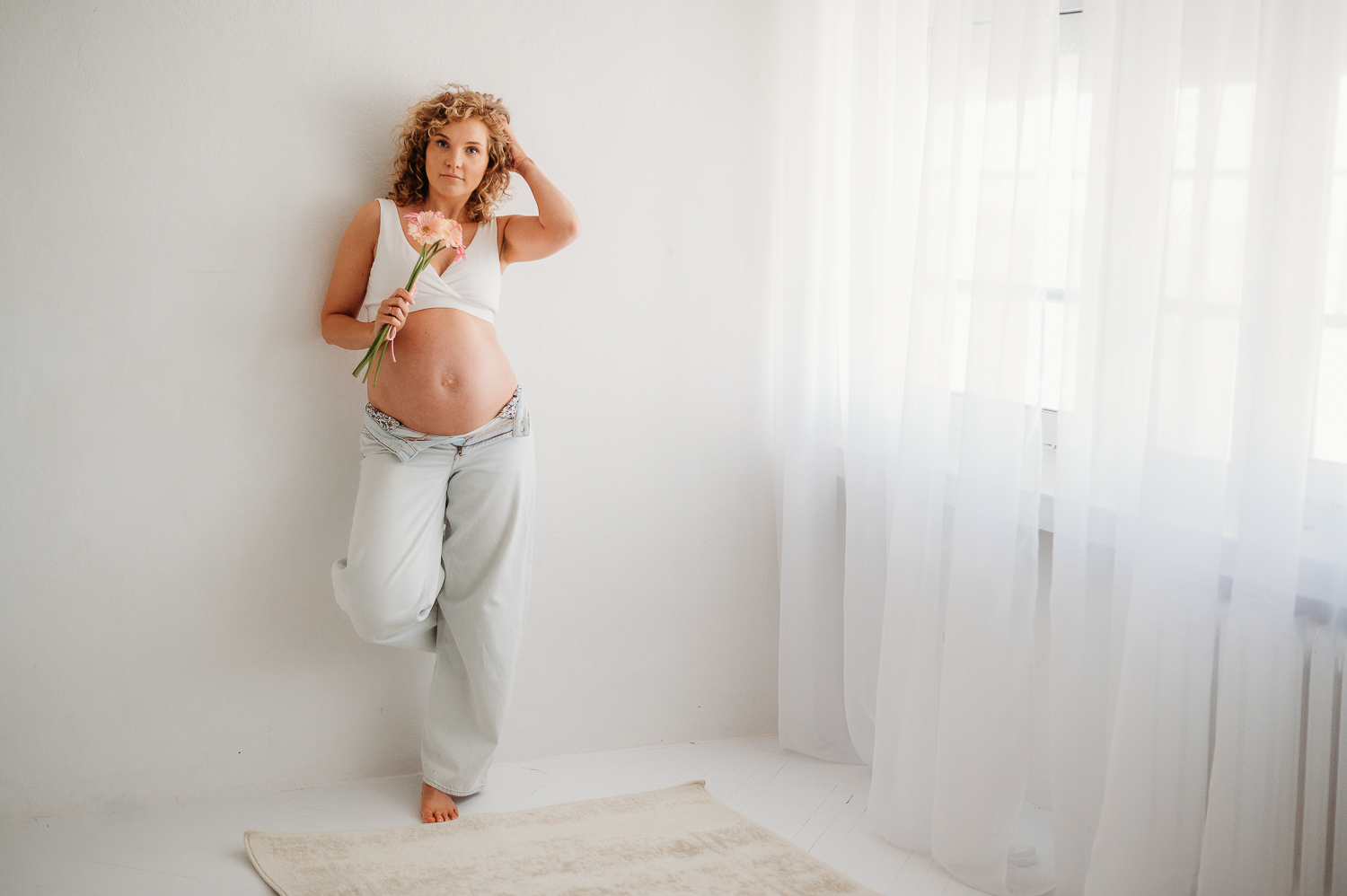 kobieta w ciąży pozuje do zdjęć w minimalistycznym studio