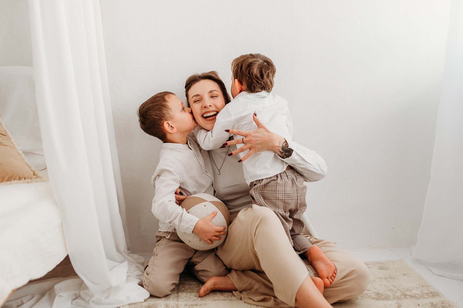jak czuć się swobodnie przed obiektywem? zdjęcie mamy z synami na  naturalnej sesji w studio