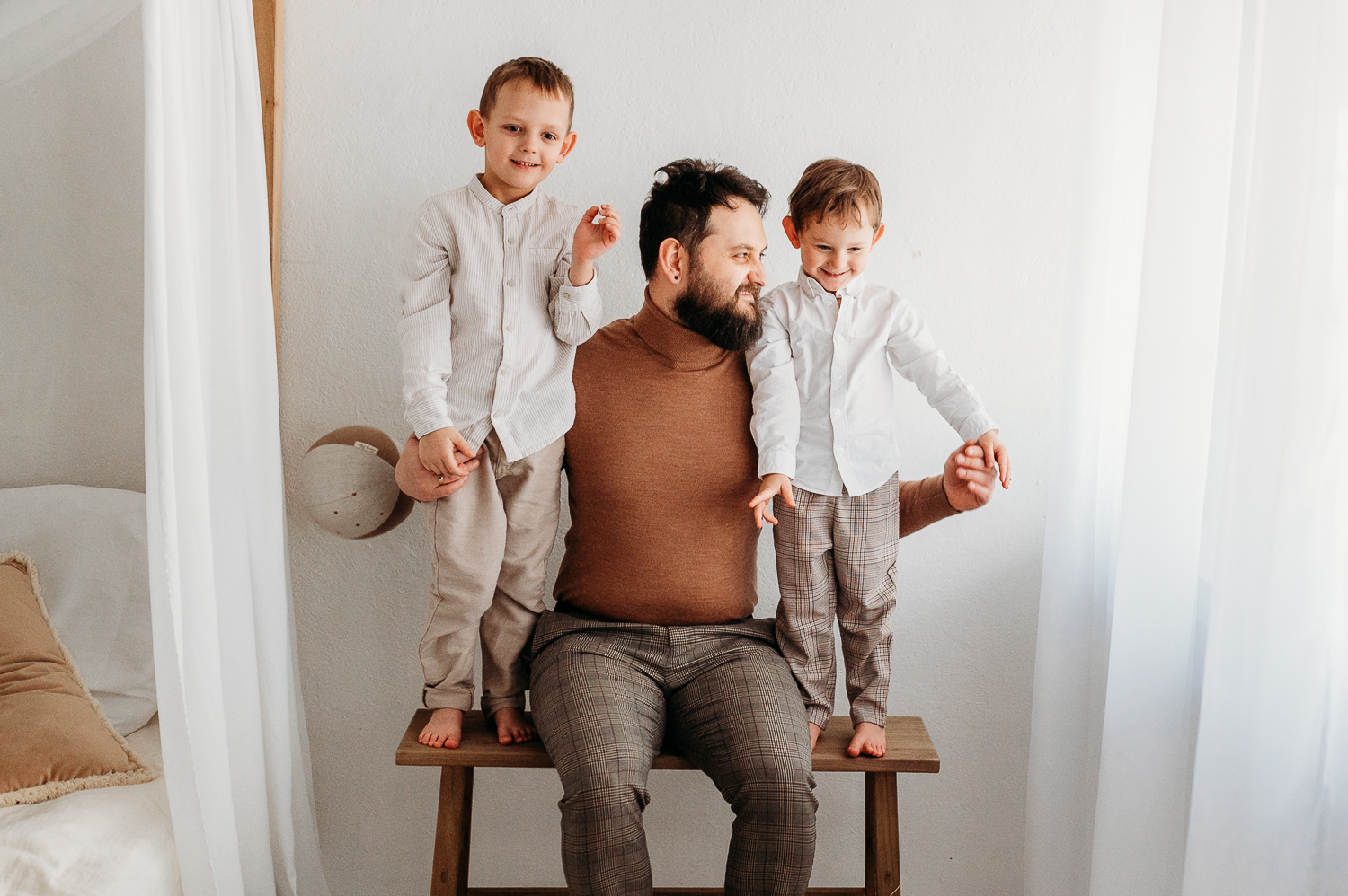 tata bawi się z synami na naturalnej sesji rodzinne w studio