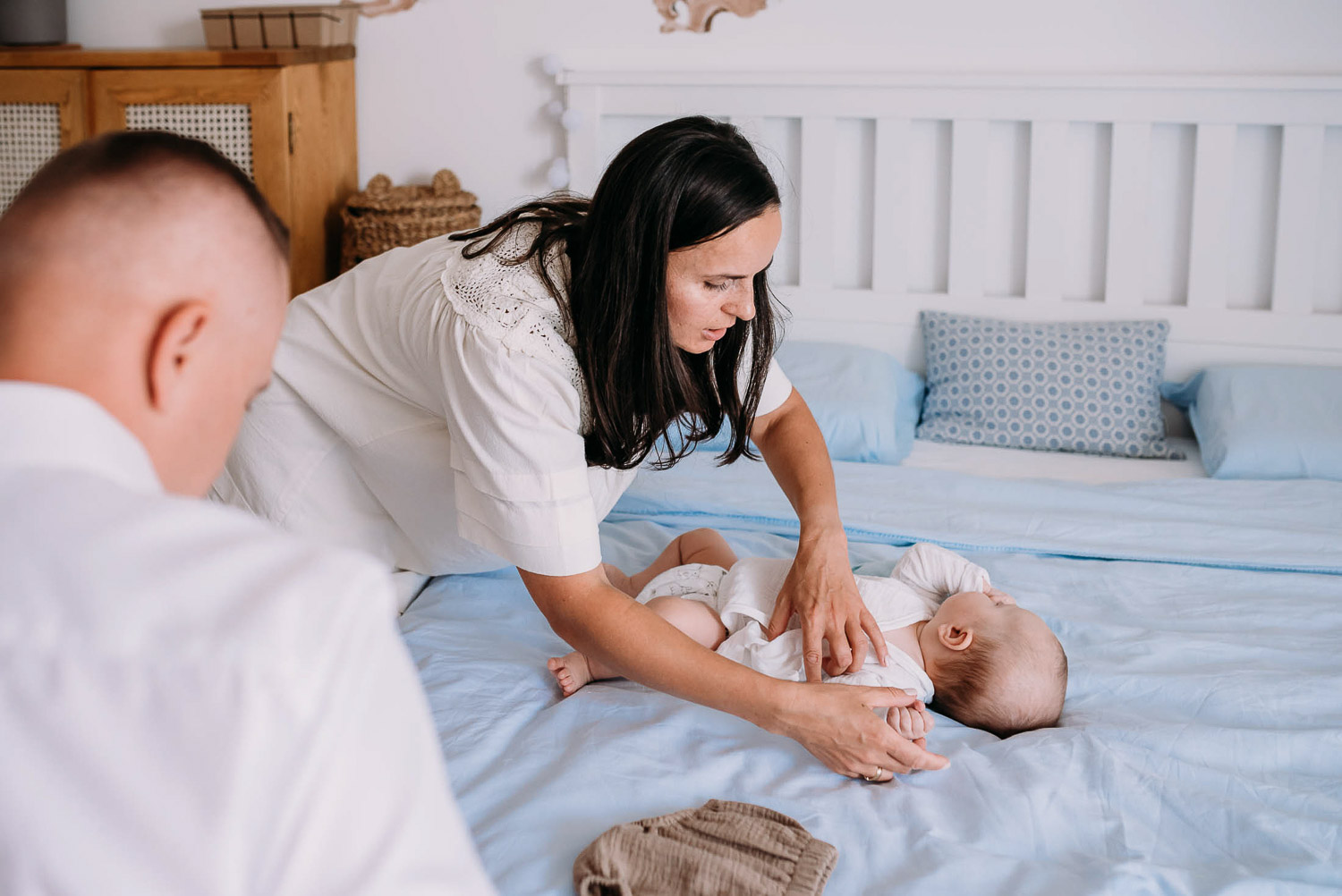 rodzice ubierają dziecka do chrztu 