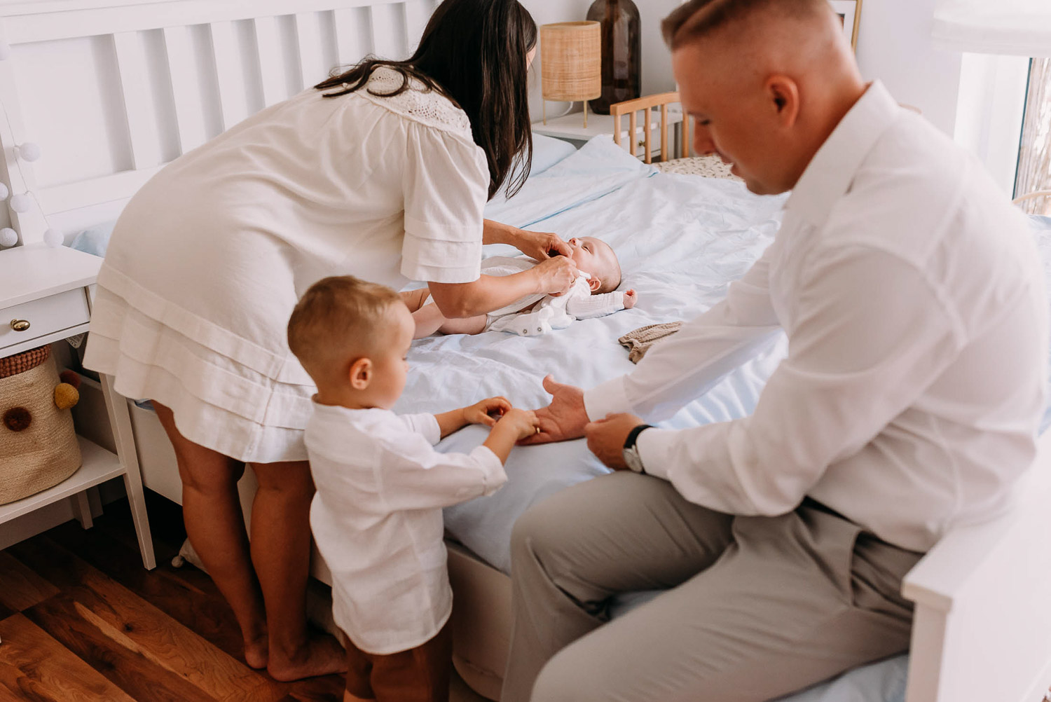 rodzice ubierają dziecko do chrztu w warszawie