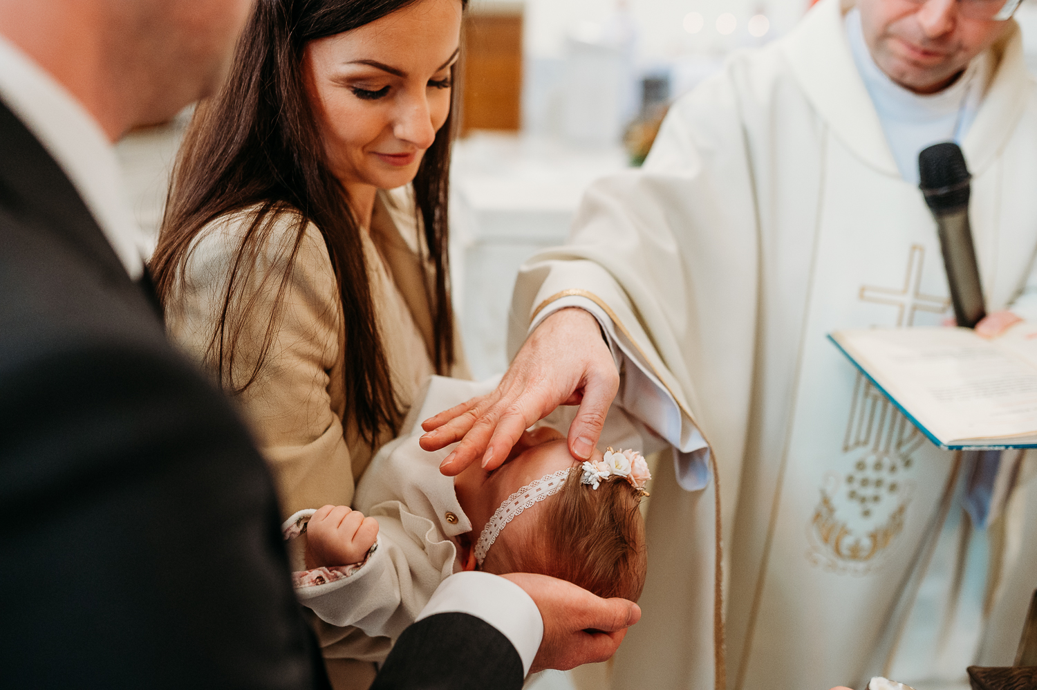 namaszczenie główki dziecka podczas chrztu - najważniejszy moment podczas reportażu z chrztu w warszawie
