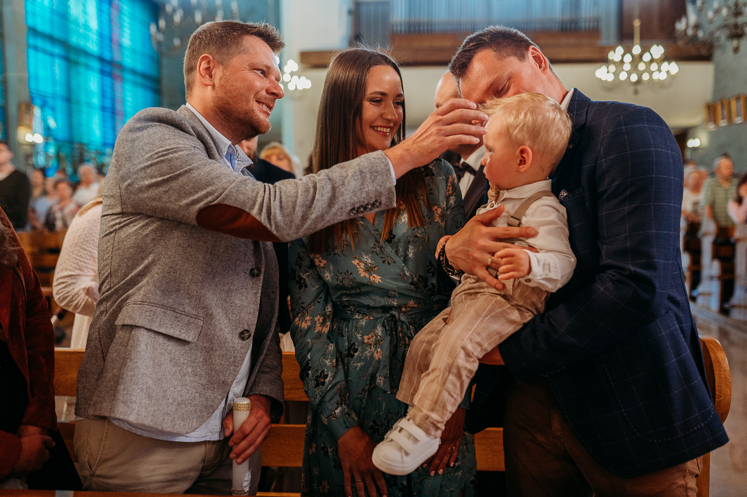 rodzice chrzestni robią znak krzyża dziecku podczas chrztu w warszawie