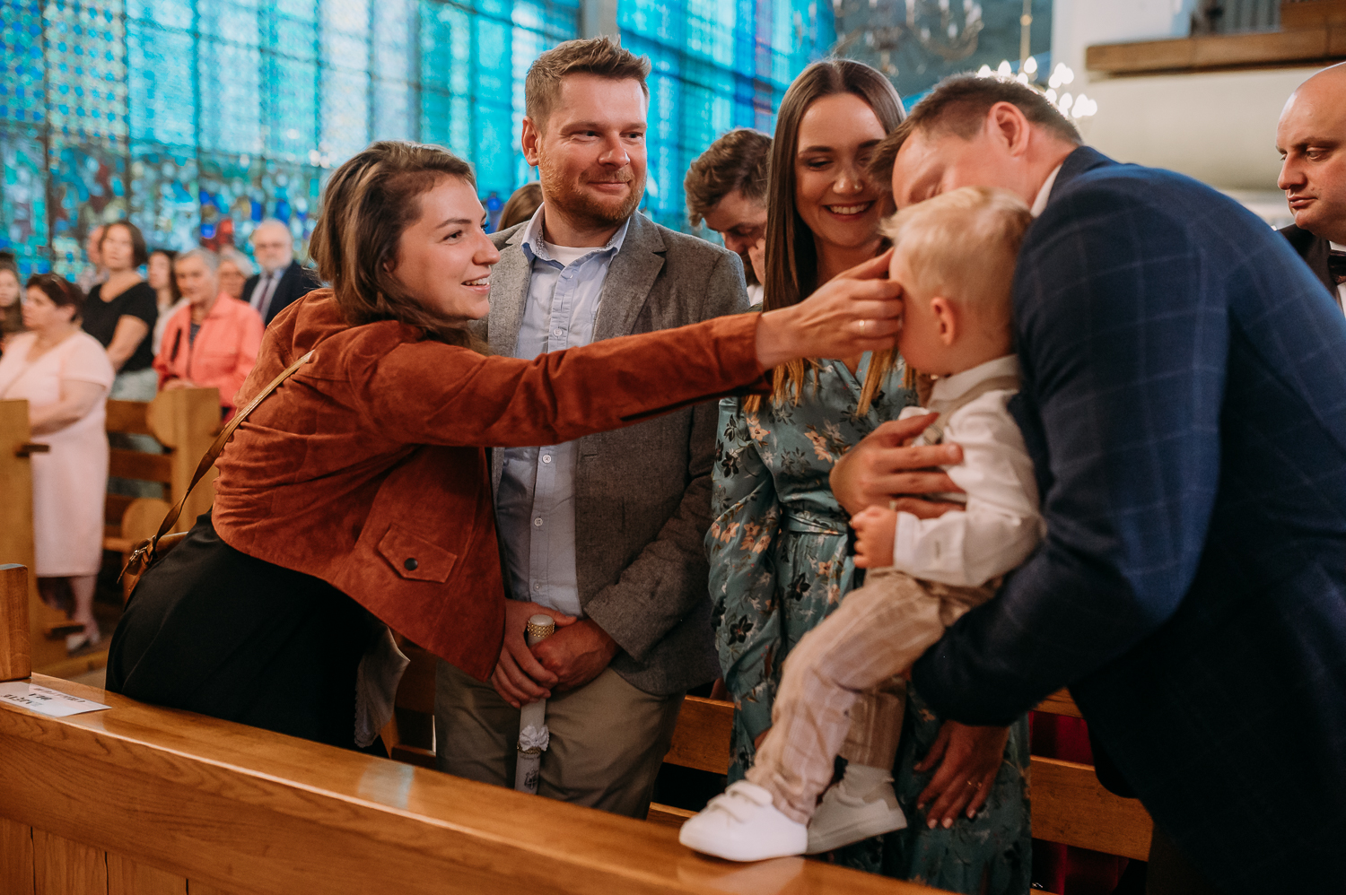 rodzice chrzestni robią znak krzyża dziecku podczas chrztu w warszawie