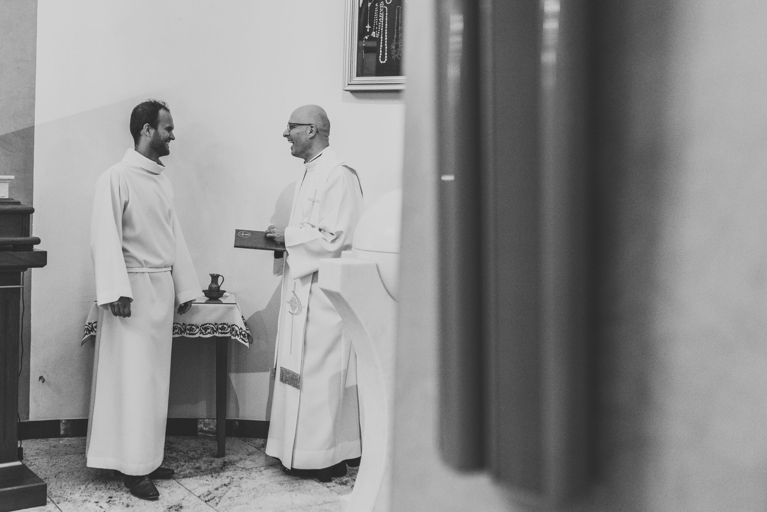 księża stoją i. rozmawiają podczas chrztu w Warszawie