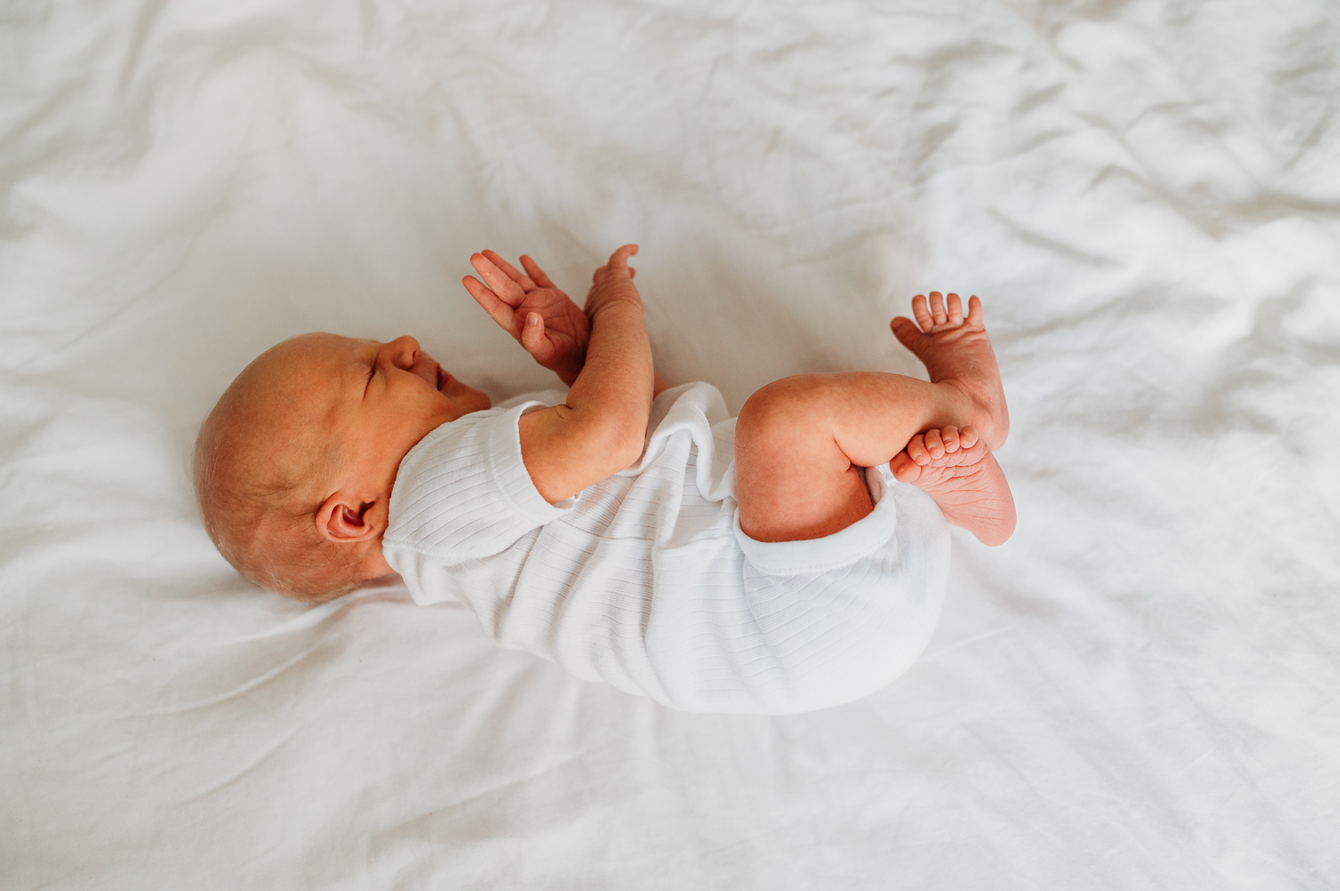 noworodek leży na łóżku w sypialni u rodziców