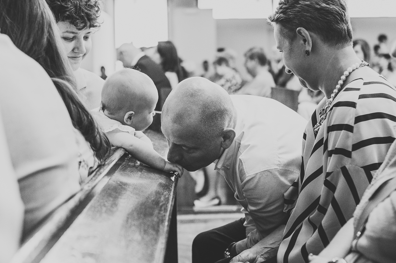 dziadek całuje rączkę wnuczki podczas mszy uchwycone przez fotograf na chrzest warszawa