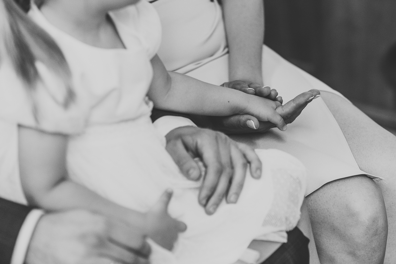 zbliżenie na złączone dłonie mamy i córki podczas chrztu w kościele w Warszawie