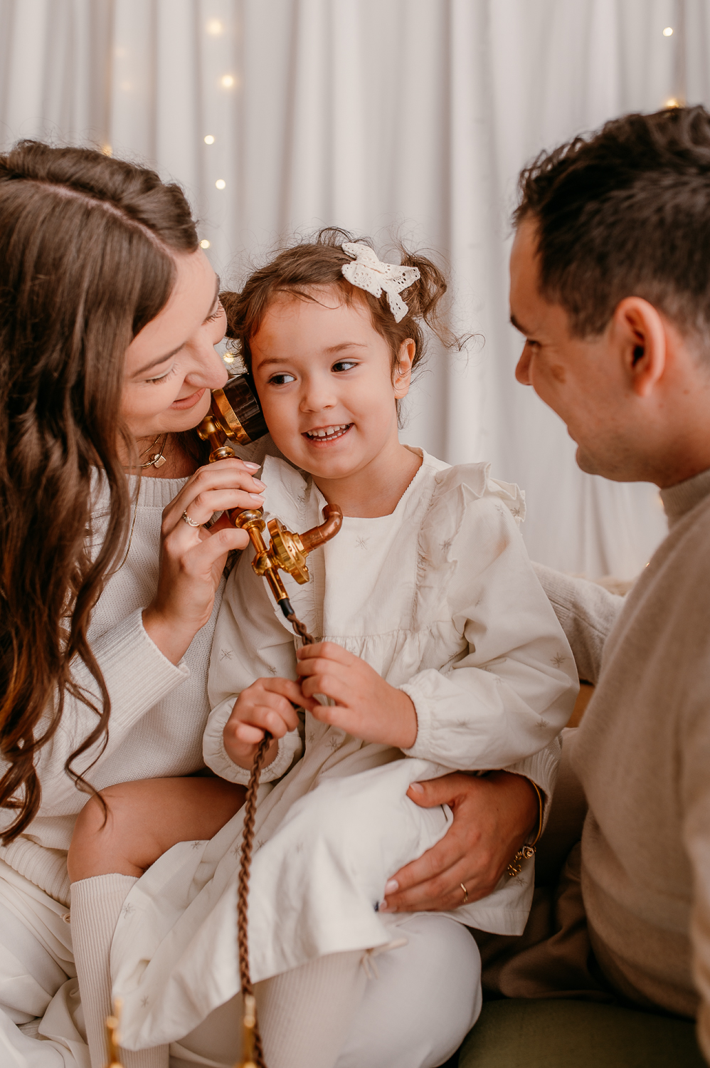 rodzina siedzi razem i udaje, że dzwoni do Mikołaja po prezenty<br />
