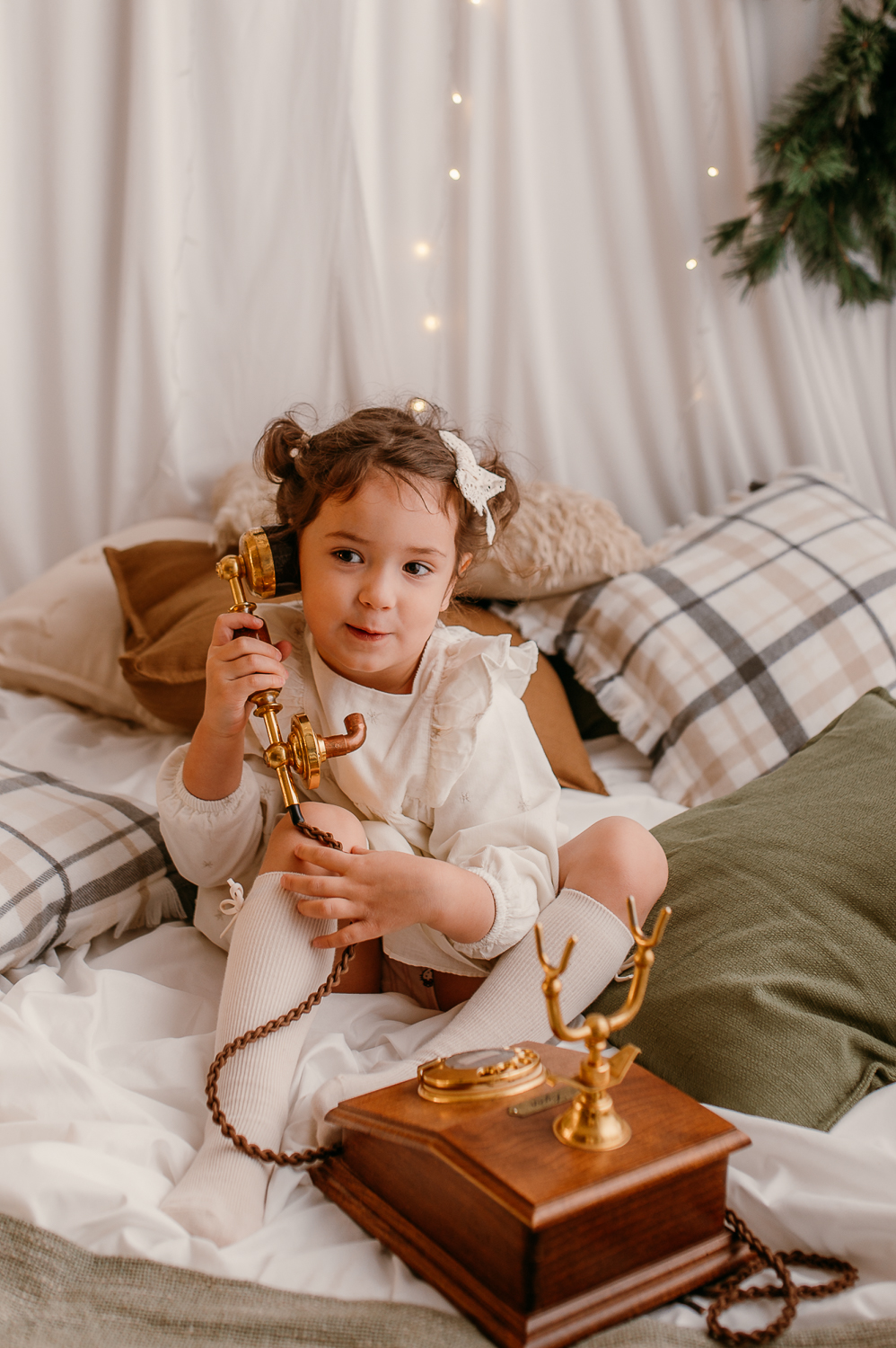 dziewczynka trzyma zabytkowy telefon i udaje, że dzwoni do Mikołaja 