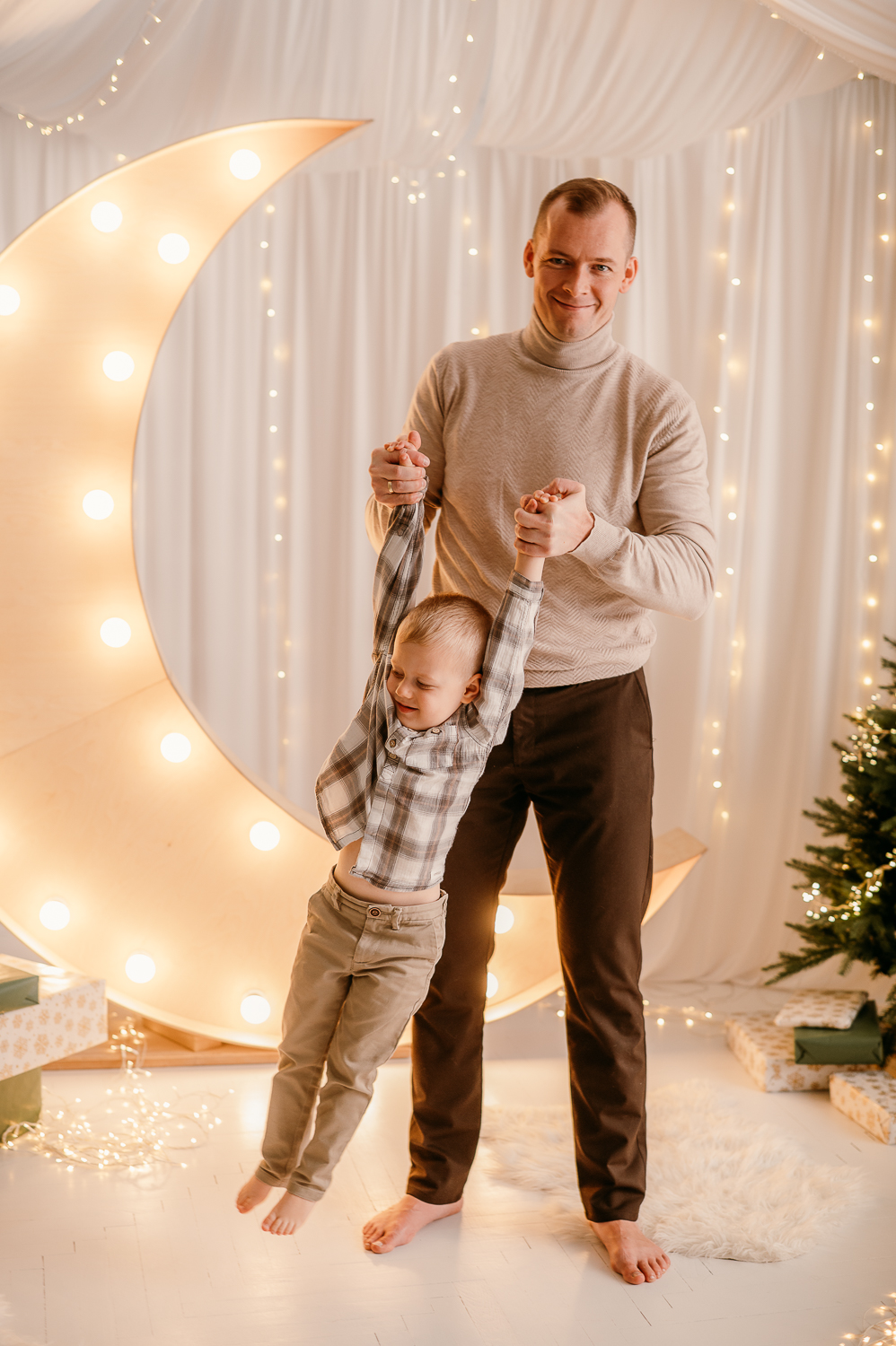 tata robi z dzieckiem wahadełko podczas rodzinnej mini sesji świątecznej w warszawie