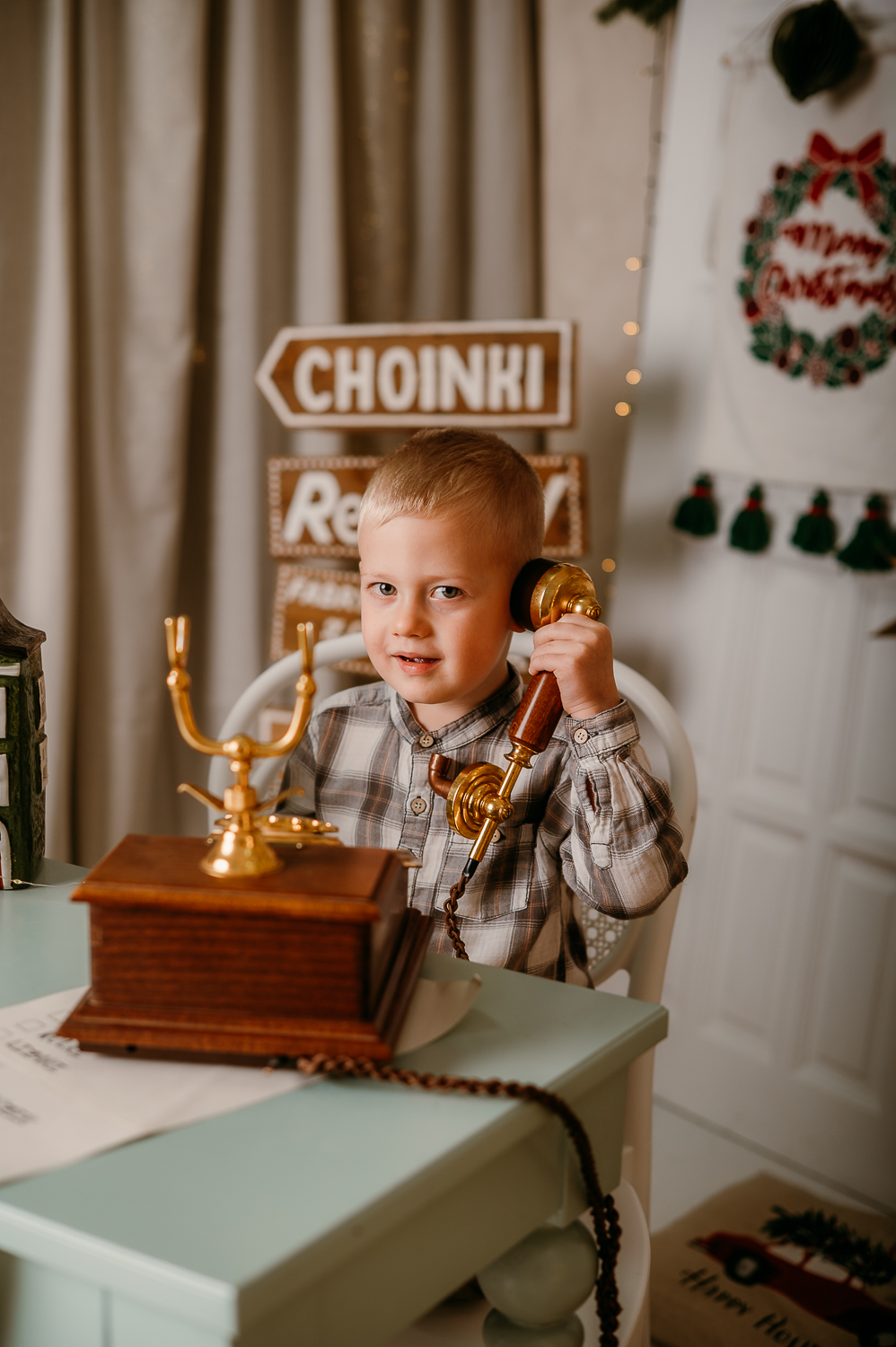 chłopie dzwoni przez zabytkowy drewniany telefon<br />
