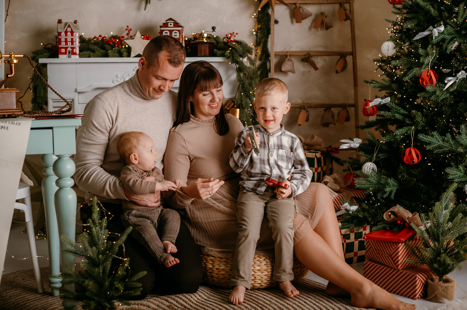 rodzina siedzi przy choince podczas rodzinnej mini sesji świątecznej w studio w warszawie