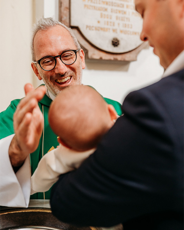 home-chrzest ksiądz namaszcza dziecku główkę podczas mszy i chrztu