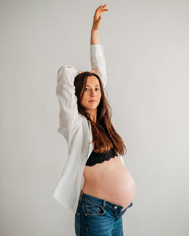 home-sesja-ciążowa kobieta pozuje do zdjęć w studio podczas sesji ciążowej