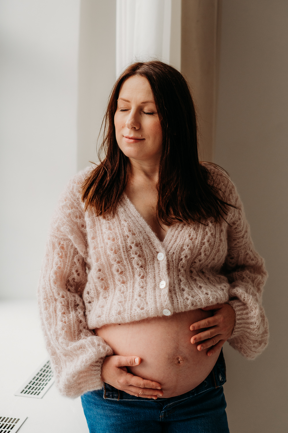 kobieta w moherowym sweterku pozuje do zdjęć w ciąży w warszawie