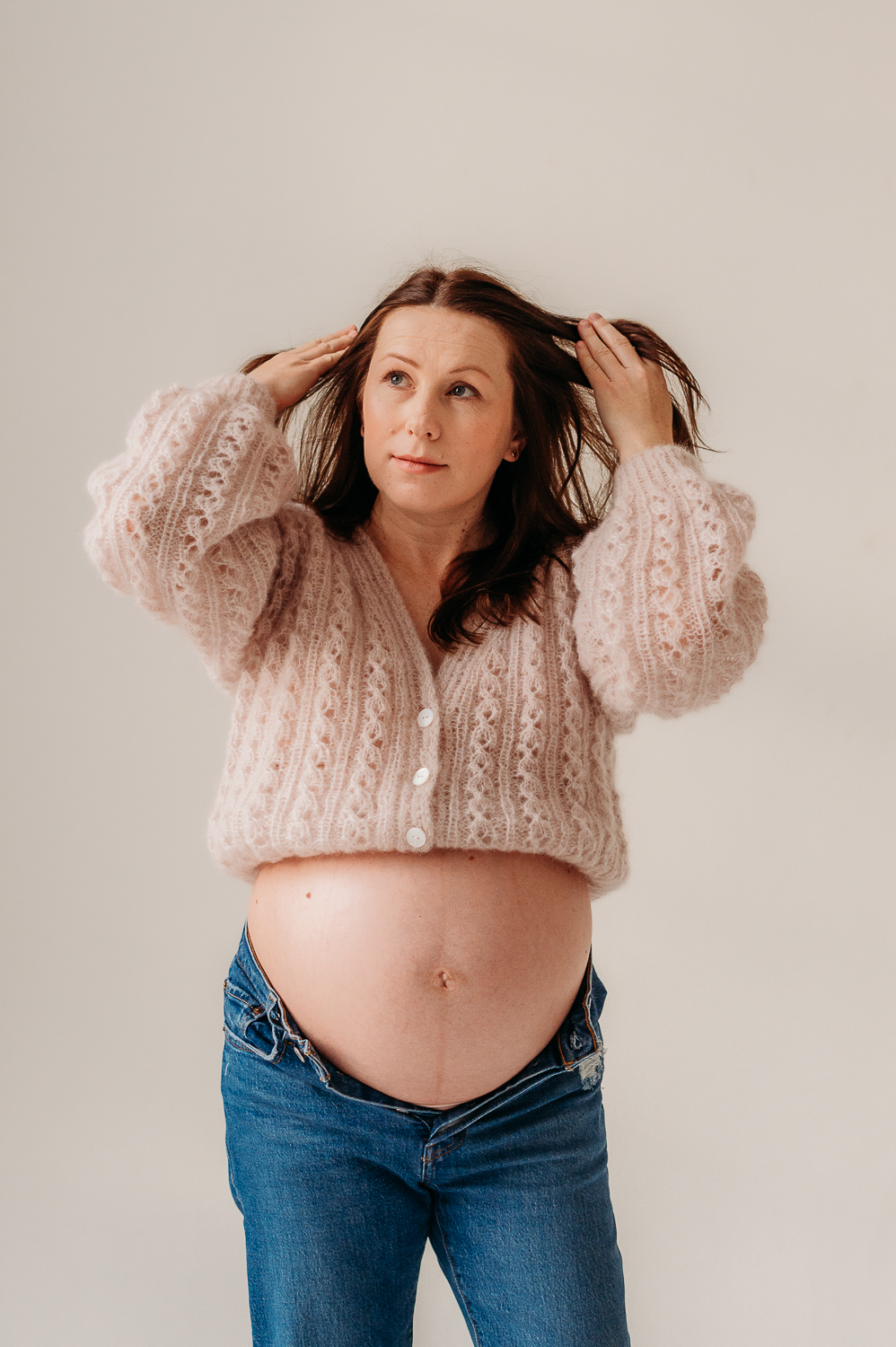 kobieta w moherowym sweterku pozuje do zdjęć w ciąży w warszawie