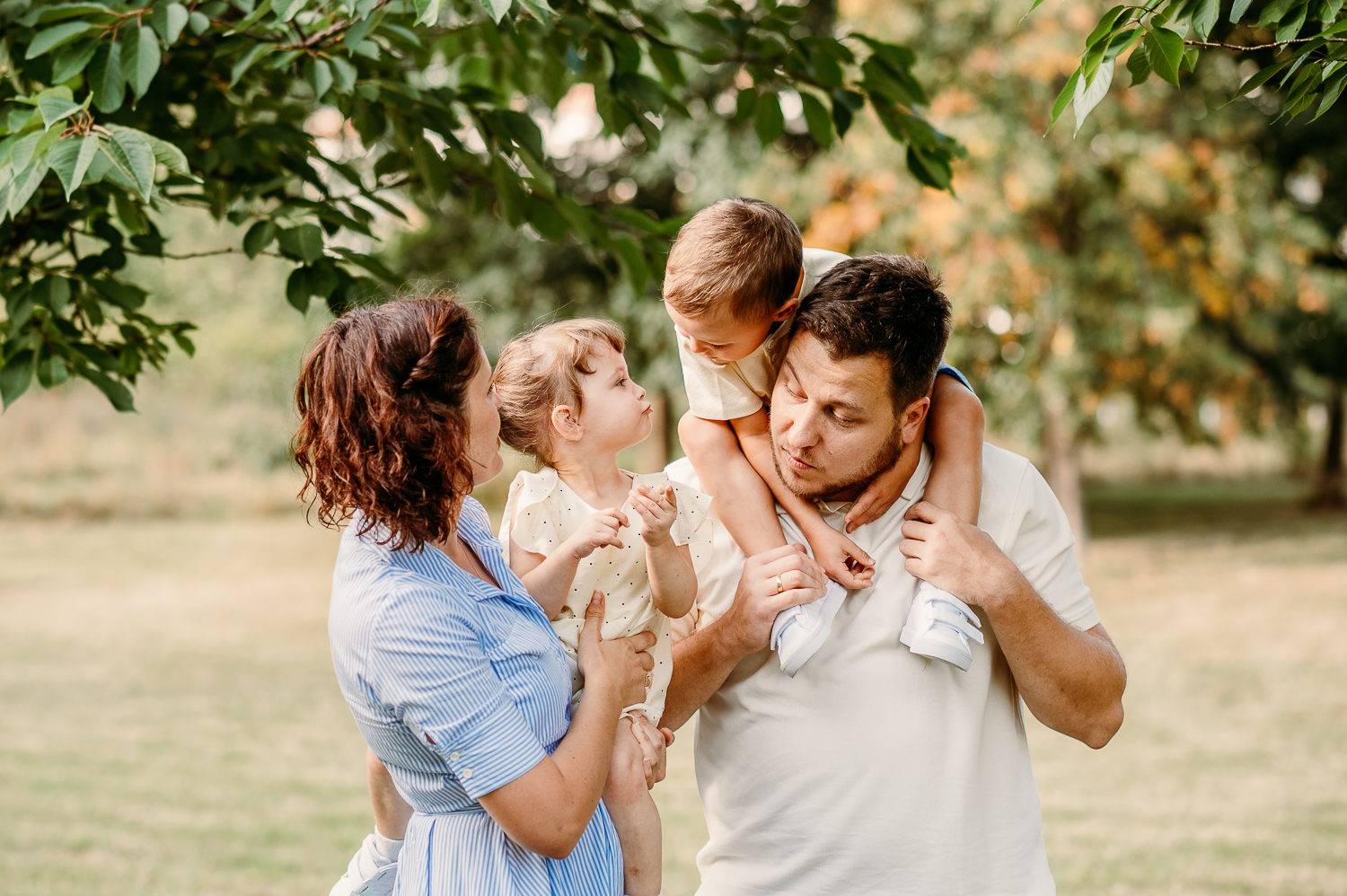 Rodzina przytula się razem podczas sesji zdjęciowej w plenerze w warszawie