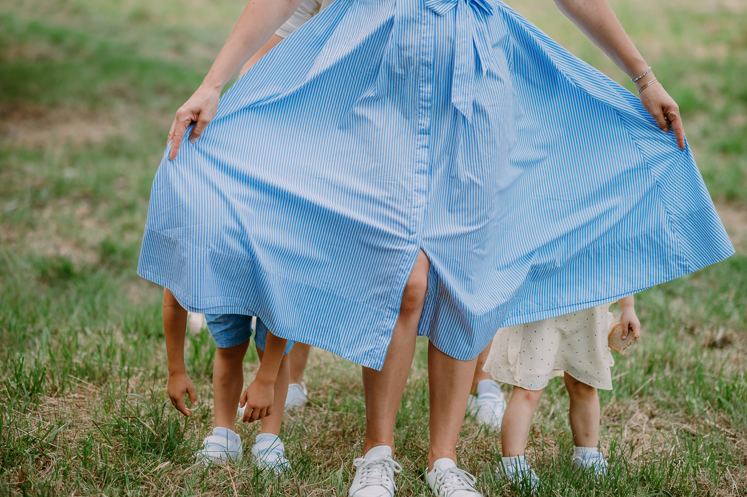 dzieci chowają się za spódnicą mamy podczas sesji z dziećmi w warszawie