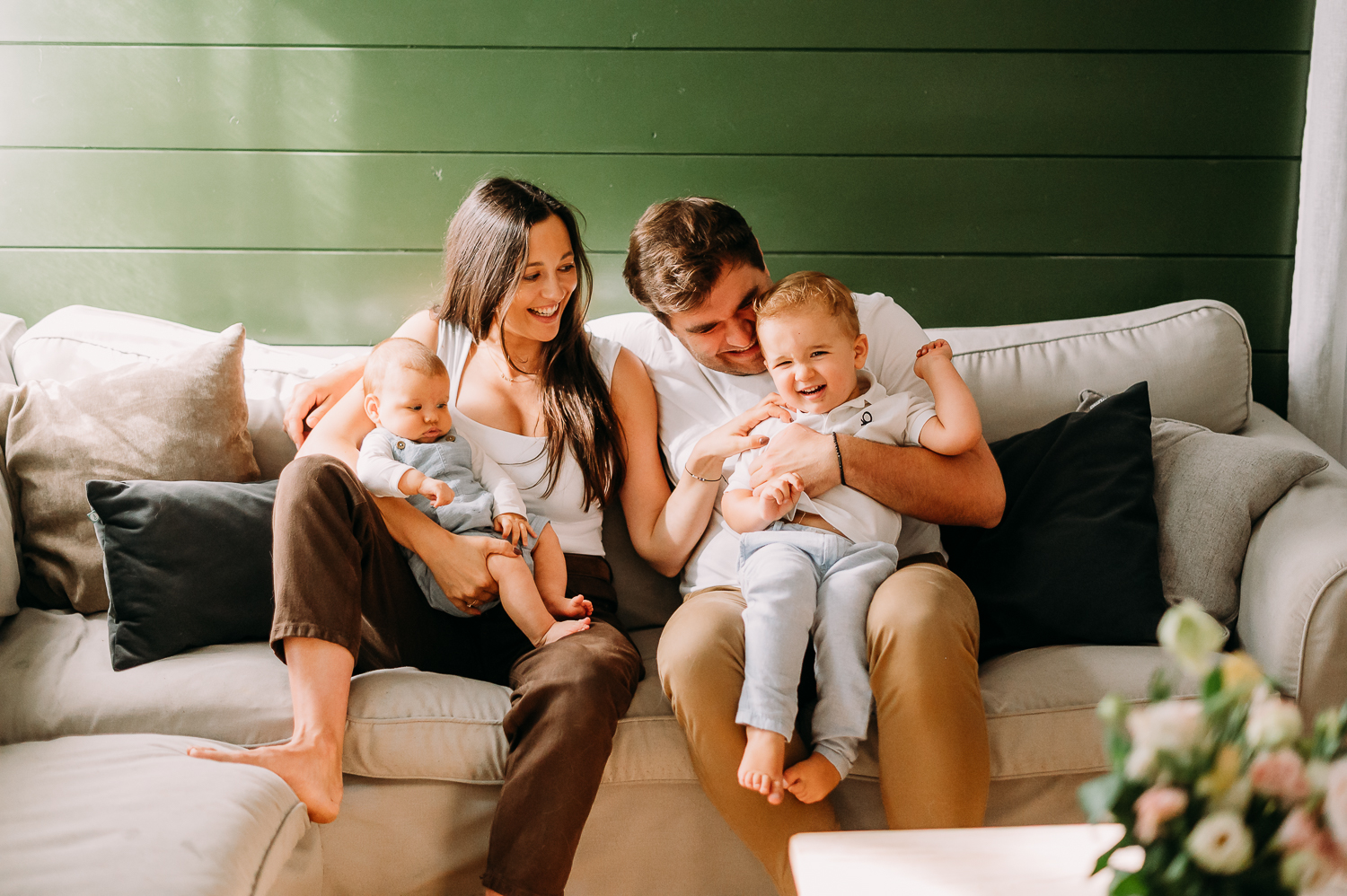 rodzina siedzi na kanapie i się przytula podczas sesji zdjęciowej z dzieckiem w Warszawie