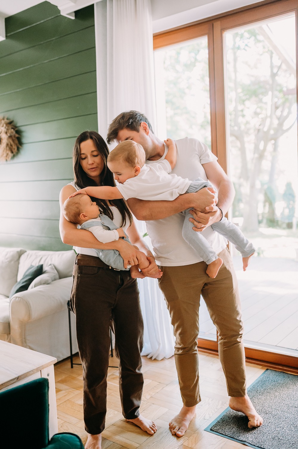 Jak może wyglądać sesja zdjęciowa z dzieckiem w Warszawie, zdjęcie rodziny stojącej w domu, mały chłopiec głaszcze swojego młodszego brata po głowie