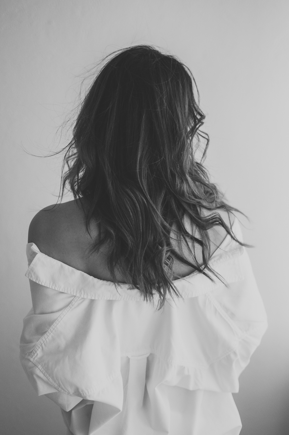 czarno białe zdjęcie kobiety, która stoi tyłem i potrząsa włosami zrobione podczas sesji kobiecej w warszawie